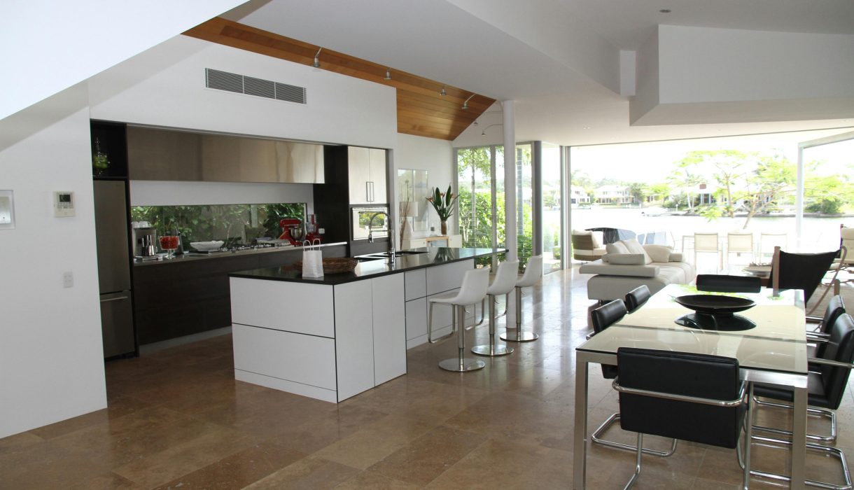 Spacious modern kitchen and living room with open design overlooking a scenic outdoor view.